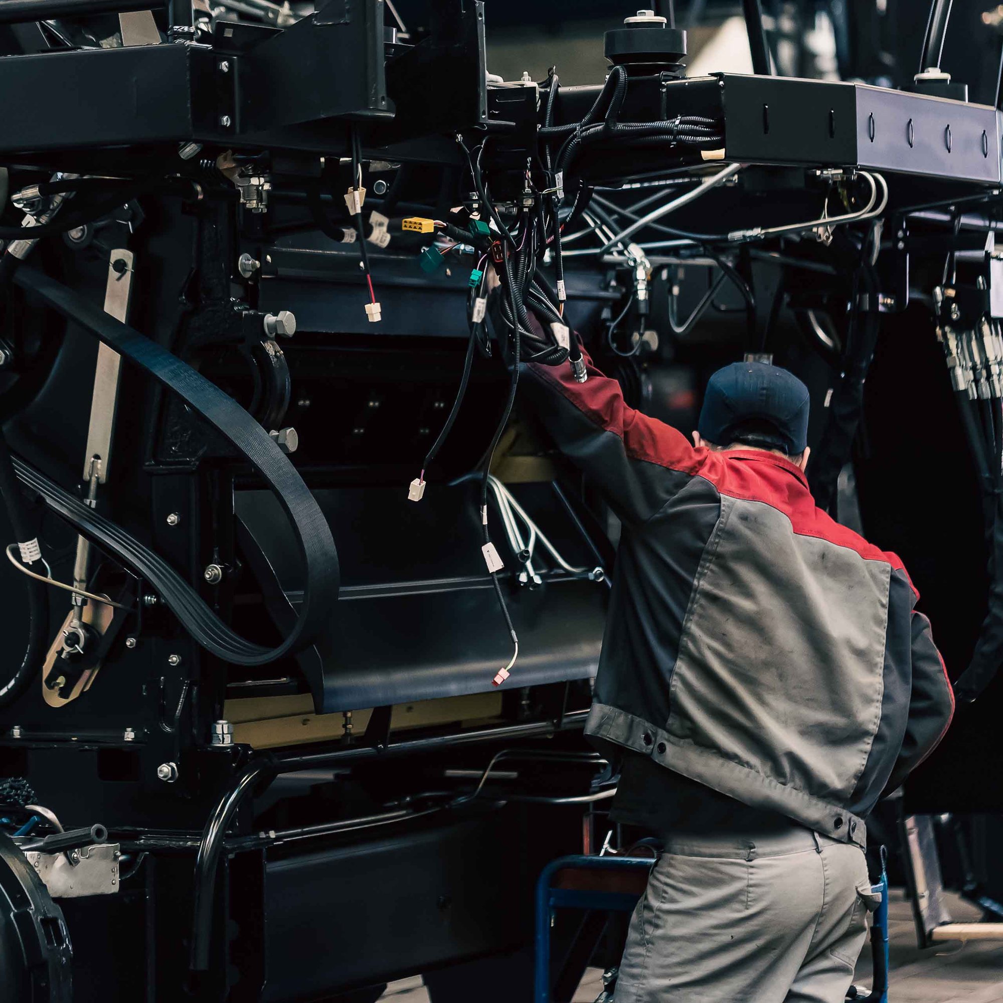 industrial worker assembles agricultural equipment