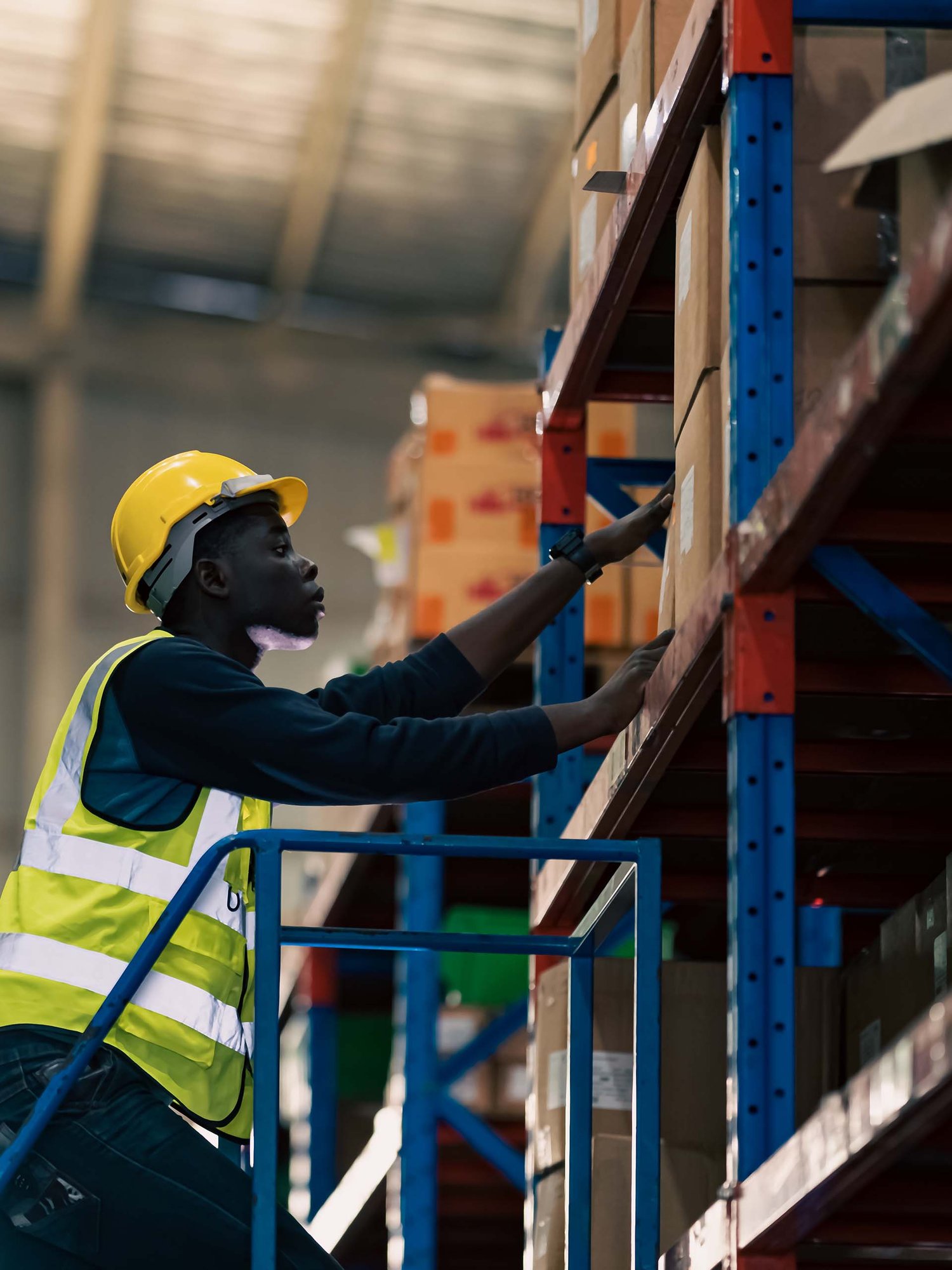 warehouse worker climbing staircase to grab boxes