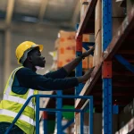 warehouse worker climbing staircase to grab boxes